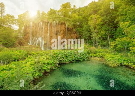 Die Sonne am Wasserfall Veliki Prstavac spiegelt sich im Potok Plitvice See des Nationalparks Plitvice in Kroatien wider. UNESCO-Weltkulturerbe von Kroatien Stockfoto