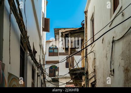 STONE TOWN, TANSANIA - 22. Dezember 2021: Enge Gassen und alte Häuser in Stone Town, Sansibar, Tansania Stockfoto