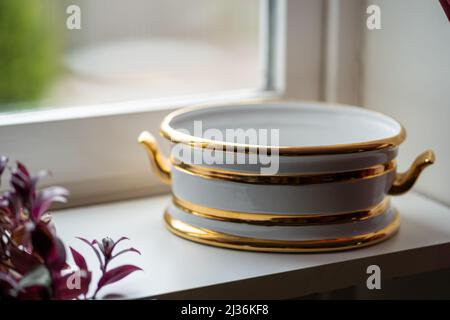 Arrangement eines luxuriösen Porzellan-Geschirrs mit goldener Hand bemalt. Innenelement Stockfoto