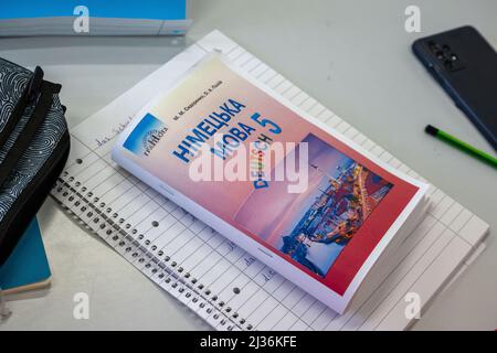 München, Deutschland. 06. April 2022. In einer Willkommensklasse am Trudering Gymnasium liegen selbstgefertigte Unterrichtsmaterialien für Schüler aus der Ukraine auf einem Tisch. Kredit: Peter Kneffel/dpa/Alamy Live Nachrichten Stockfoto