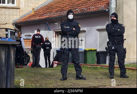 Eisenach, Deutschland. 06. April 2022. Polizeibeamte stehen vor einem Hintereingang eines Gebäudes, das sie durchsuchen. Die Ermittler haben seit dem Morgen Maßnahmen gegen mutmaßliche Rechtsextremisten ergriffen. Vier Personen, die mit einer Kampfsportgruppe in Eisenach in Verbindung stehen, wurden verhaftet, teilte eine Sprecherin der Bundesanwaltschaft in Karlsruhe am Mittwoch mit. Quelle: Martin Wichmann TV/dpa/Alamy Live News Stockfoto