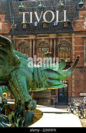 Bronzestatue, die einen Chimäre-Drachen darstellt, mit einem der Eingänge zum Vergnügungspark Tivoli dahinter. Kopenhagen, Dänemark, Europa Stockfoto