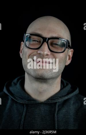 Porträt eines kahlen jungen Mannes mit lächelnden Brillen Stockfoto