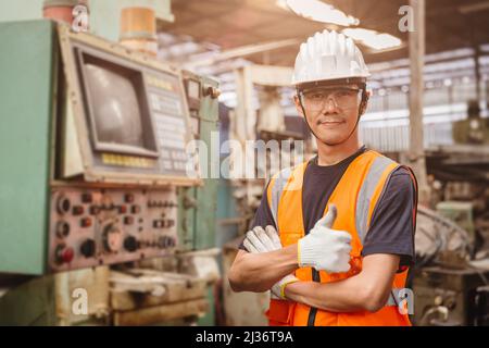 Selbstbewusster asiatischer Ingenieur Arbeiter Mann stand Arm kreuzte glückliches Lächeln für Freude in der Fabrik arbeiten Stockfoto