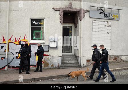 Eisenach, Deutschland. 06. April 2022. Polizeibeamte stehen vor dem Pub „Bull's Eye“. Die Ermittler haben seit dem Morgen Maßnahmen gegen mutmaßliche Rechtsextremisten ergriffen. Vier Personen aus dem Umfeld einer Kampfkunstgruppe in Eisenach seien verhaftet worden, sagte eine Sprecherin der Bundesanwaltschaft in Karlsruhe am Mittwoch. Quelle: Martin Schutt/dpa/Alamy Live News Stockfoto