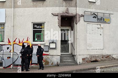 Eisenach, Deutschland. 06. April 2022. Polizeibeamte stehen vor dem Pub „Bull's Eye“. Die Ermittler haben seit dem Morgen Maßnahmen gegen mutmaßliche Rechtsextremisten ergriffen. Vier Personen aus dem Umfeld einer Kampfkunstgruppe in Eisenach seien verhaftet worden, sagte eine Sprecherin der Bundesanwaltschaft in Karlsruhe am Mittwoch. Quelle: Martin Schutt/dpa/Alamy Live News Stockfoto