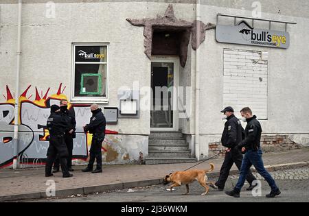 Eisenach, Deutschland. 06. April 2022. Polizeibeamte stehen vor dem Pub „Bull's Eye“. Die Ermittler haben seit dem Morgen Maßnahmen gegen mutmaßliche Rechtsextremisten ergriffen. Vier Personen aus dem Umfeld einer Kampfkunstgruppe in Eisenach seien verhaftet worden, sagte eine Sprecherin der Bundesanwaltschaft in Karlsruhe am Mittwoch. Quelle: Martin Schutt/dpa/Alamy Live News Stockfoto