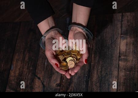 Frauen mit Handschellen und einer Handvoll Euro-Münzen Stockfoto