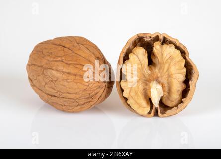 Gerissene Walnüsse und ganze Walnüsse auf weißem Hintergrund Stockfoto