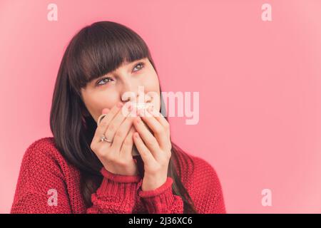 Junge hübsche europäische Frau trinkt Tee, Kaffee und suchen Studio geschossen isoliert rosa Hintergrund kopieren Raum Medium Nahaufnahme . Hochwertige Fotos Stockfoto