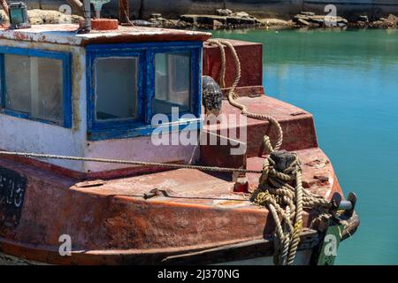 Kabine und Bug eines alten, ungenutzten und sich verschlechternden Bootes im Wasser. Stockfoto