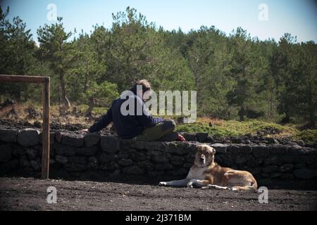 ÄTNA PARK, SIZILIEN, ITALIEN - 06. OKTOBER 2018: Mann und Hund ruhen sich in den Bergen aus Stockfoto