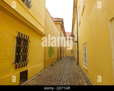 Prager Allee in der Altstadt, Praha Narrow Street mit alten Kopfsteinpflaster und gelben Gebäuden, Gasse mittelalterliche Straße, Jüdisches Viertel, Tschechische Republik Stockfoto