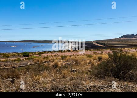 Große Solarfarm in einer abgelegenen Halbwüste, mit paralel Reihen von Photovoltaik-Panels. Stockfoto