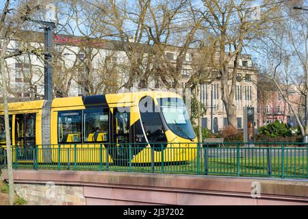 Mulhouse, Frankreich - 19. Dez 2015: Schnellfahrt der gelben Straßenbahn von Mulhouse mit öffentlichem Nahverkehr und Mercure Hotel im Hintergrund Stockfoto