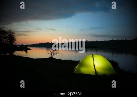 Sehen Sie das beleuchtete Zelt am Biviere See im Nebrodi Park bei Nacht, Sizilien Stockfoto