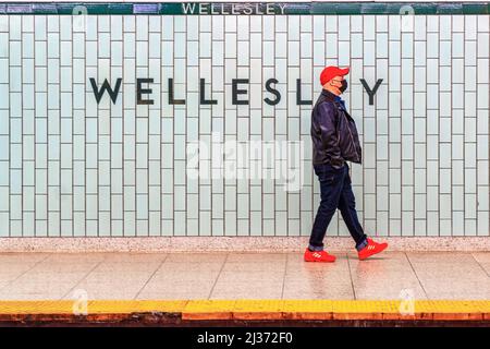 Ein Mann mit Gesichtsmaske und roten Schuhen geht auf dem Bahnsteig der Wellesley U-Bahnstation, die zum TTC gehört. Die Toronto Transit Commission ist t Stockfoto