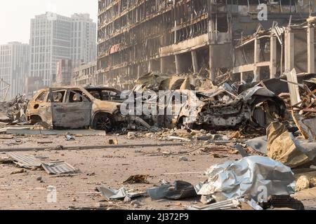 2022 Russische Invasion der Ukraine Krieg zerrissene Stadt zerstört Auto brennen aus. Kriegsverbrechen Russland bombardiert Gebäude Schäden Autos Zerstörung Stadt Ruinen Gebäude Stockfoto