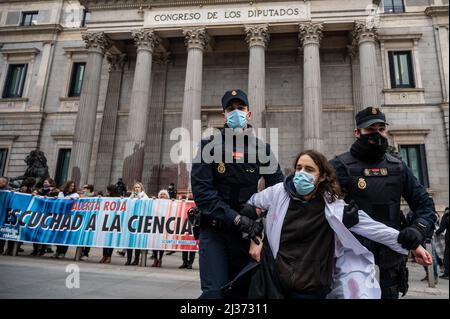 Madrid, Spanien. 06. April 2022. Polizeibeamte entfernen einen Klimaaktivisten der Gruppe der Wissenschaftler-Rebellion aus dem Protest vor dem Kongress der Abgeordneten. Aktivisten der Wissenschaftlichen Rebellion, die von der Extinction Rebellion Group unterstützt werden, haben einen Protest gegen den Kongress der Abgeordneten durchgeführt, der einen friedlichen Akt des Ungehorsams vollbrachte, um die Untätigkeit der Regierungen im Kampf gegen den Klimawandel zu verurteilen. Quelle: Marcos del Mazo/Alamy Live News Stockfoto