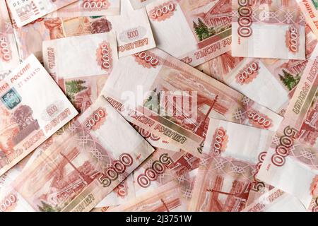 Banknoten von russischen 5000 Rubel. Bundle von fünftausendsten Banknoten. Fünftausendste Banknoten russischer Rubel drehen sich auf einer Plattform, die mit m bedeckt ist Stockfoto