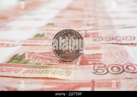 Russische Rubel-Münzen auf 5000 Rubel-Banknoten, Nahaufnahme Hintergrund. Hintergrund aus Geld. Stockfoto