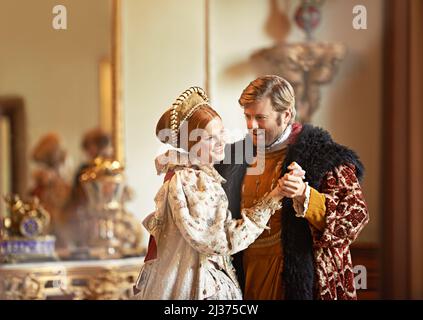 Eine zeitlose Liebe teilen. Ein König und eine Königin tanzen in ihrem Palast zusammen. Stockfoto