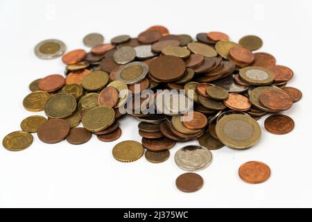 Metallstapel von Münzen isoliert auf weißem Hintergrund, verschiedene Veränderung verschüttet auf Plattform, unordentliches Geld, sparen Münze Stockfoto