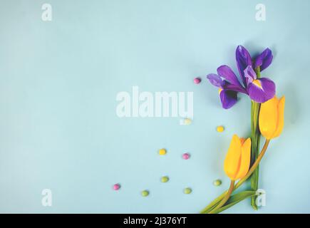 Ostereier, Tulpen und Bonbons in einem Rahmen. Frühlingsferien Hintergrund. Stockfoto