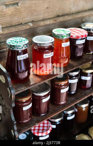 Hausgemachte Marmeladen und Konfitüren (Honesty Box auf der Veranda der St. Mary the Virgin Church in Great Wymondley, Hertfordshire, Großbritannien) Stockfoto