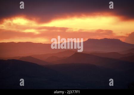 Roter Sonnenuntergang auf geschichteten Hügeln des Simeto-Tals, Sizilien Stockfoto