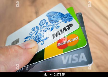 2. April 2022. Barnaul. Russland: Bankkarten mit Logos von drei Zahlungssystemen: Visa, Mastercard und mir. Stockfoto