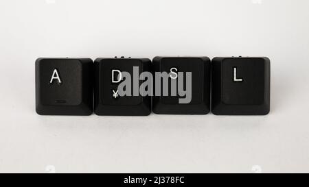 ADSL-Text erstellt mit isolierten Tastaturtasten auf weißem Hintergrund, weißem adsl auf schwarzer Tastatur, Draufsicht Stockfoto