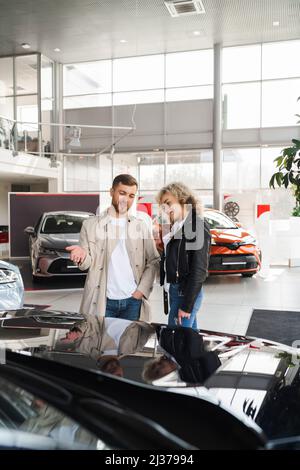 Schönes junges Paar in einem Autohaus wählen Sie ein Auto Stockfoto