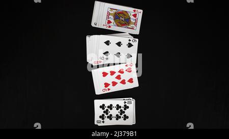 Mehrere Spielkarten Deck, Unterhaltung mit Karten, aufgereiht, isoliert auf schwarzem Hintergrund, Draufsicht Stockfoto