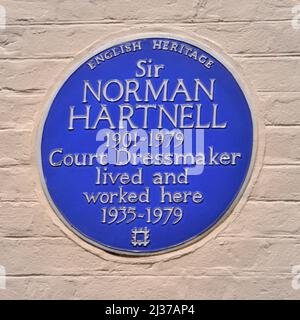 English Heritage historische blaue Wandtafel Sir Norman Hartnell Court Schneiderin lebte und arbeitete hier in Mayfair von 1935 - 1979 London England UK Stockfoto