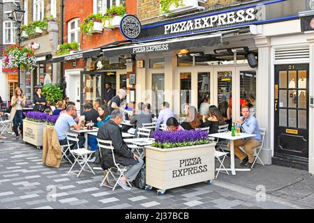 Gäste sitzen vor dem Pizza Express Restaurant, essen im verkehrsfreien St Christophers Place in der Nähe der Oxford Street, London West End, Großbritannien, draußen und essen im Freien Stockfoto
