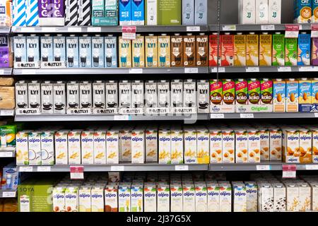 Reihen Reihe von Milchalternativen pflanzliche Milchprodukte frei zum Verkauf auf Waitrose Supermarkt Regale Regal Oatly Alpro Koko Rude Health Drinks London UK 2022 Stockfoto