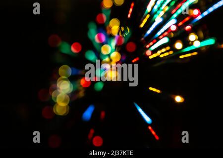 Bewegungsunschärfe-Effekt von langbelichteten LED-Lichtern. Abstrakter Hintergrund mit Bokehs und Lichtausbrüchen. Valentinstag, Party, Weihnachten, Frohes Neues Jahr Stockfoto