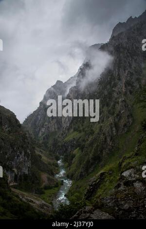 Scharfe Kalksteinfelsen und tiefe Schluchten unter den Wolken an einem grauen Regentag Stockfoto