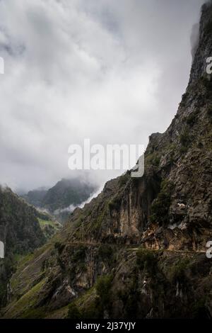 Scharfe Kalksteinfelsen und tiefe Schluchten unter den Wolken an einem grauen Regentag Stockfoto