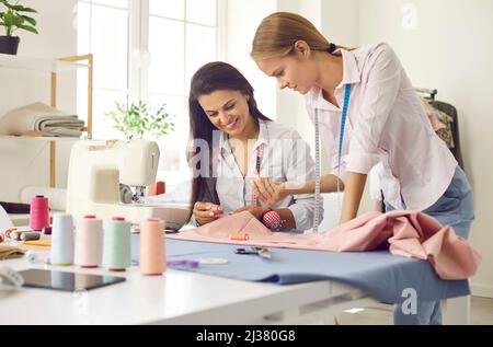 Schneiderinnen arbeiten im Modeatelier zusammen Stockfoto