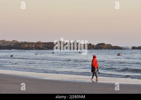 Frau, die am Abend am Strand Praia Internacional spazieren geht, Porto Portugal. Stockfoto