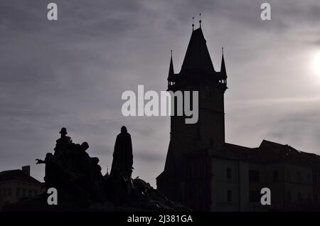 Der Turm des Staroměstská radnice (altes Rathaus) und das Jan Hus-Denkmal wurden vor dem trüben Morgenlicht auf dem Altstädter Ring in Prag, Tschechien, dargestellt. Stockfoto