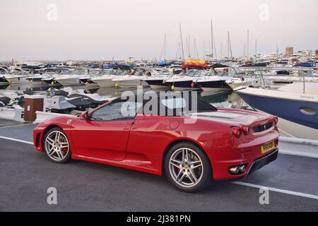 Ferrari Sportwagen und Yachten in Puerto Banus, einem luxuriösen Ferienort im Südwesten von Marbella in Andalusien, Spanien. Stockfoto