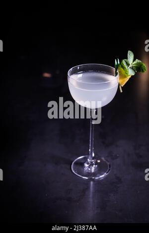 Eine vertikale Aufnahme eines klassischen South Side-Cocktails mit Limette und Minze auf schwarzem Hintergrund Stockfoto