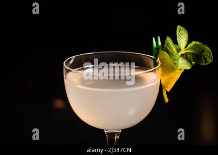 Ein klassischer Cocktail auf der Südseite mit Limette und Minze auf schwarzem Hintergrund Stockfoto