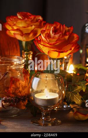 Herbsthochzeit Dekoration mit Kürbissen, Orangenrosen und Kerzen. Partydekor Stockfoto