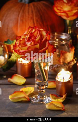 Herbsthochzeit Dekoration mit Kürbissen, Orangenrosen und Kerzen. Partydekor Stockfoto