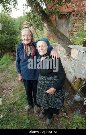 JERMA-TAL, PIROT, SERBIEN - 29. JULI 2017: Zwei unbekannte alte Frauen mit Kopftuch und Spazierstock posieren für die Kamera auf dem Land in der Nähe von Wa Stockfoto