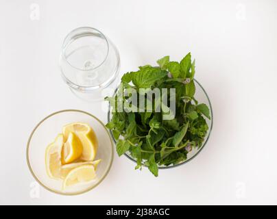 Drei Tassen Wasser mit Zitronenscheiben und Minze. Blick von oben. Entgiften Sie Wasser. Stockfoto